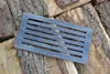 A cast iron grate is placed on a pile of firewood. Anteprima dell’immagine prodotto