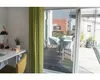 A view from inside a room looking out onto a balcony with outdoor furniture. Podgląd zdjęcia produktu