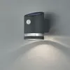 A dark gray solar-powered wall light with a motion sensor is mounted on a light gray wall, casting a downward light pattern. Anteprima dell’immagine prodotto