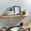 A wooden shelf with decorative items and books, above a wooden desk with office supplies. Voir les images du produit