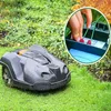 A robotic lawnmower is on a lawn, with an inset showing hands connecting wires to a charging station. Produktbild-Vorschau