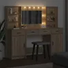 A vanity table with a mirror and lights, along with a stool, in a dimly lit room. Náhled obrázku produktu