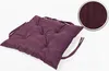 A single tufted seat cushion with ties, shown at an angle on a white background. A circular inset shows a close-up of the fabric texture. Produktbild-Vorschau
