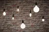 Several light bulbs hanging against a brick wall. Produktbild-Vorschau