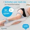 A person is lying on a bed using a knee pillow. Produktbild-Vorschau