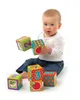 A baby sitting on the floor playing with soft foam blocks. Produktbild-Vorschau