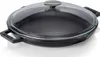 A black cast iron pan with a clear glass lid and silver handle, shown from a slightly elevated angle on a white background. Produktbild-Vorschau