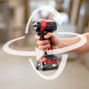 A hand holding a cordless drill with circular arrows indicating movement. Voir les images du produit