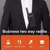 A person in a suit wearing a walkie-talkie on their lapel, with icons and text below indicating different business applications. Produktbild-Vorschau