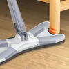 A close-up of a mop head cleaning around the leg of a wooden table. Produktbild-Vorschau