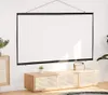 A white projection screen is hung on a white wall above a wooden media console with a small plant and a radio. Anteprima dell’immagine prodotto