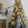 A child stands in front of a decorated Christmas tree, looking at the ornaments. Produktbild-Vorschau
