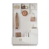 A white entryway organizer with a bench, coat hooks, shelves, and cabinets, decorated with bags, a hat, and books. Produktbild-Vorschau