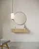 A minimalist bathroom vanity setup with a floating shelf, round mirror, and pendant light. Produktbild-Vorschau