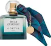 A bottle of perfume with a decorative scarf and a gold charm. Voir les images du produit