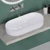 A white oval sink is placed on a gray countertop against a green wall. Produktbild-Vorschau