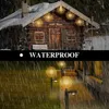 A wooden cabin decorated with starburst lights during a rainy day. Produktbild-Vorschau
