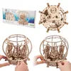 A collage of images showing a wooden 3D puzzle of a mechanical aquarium, its packaging, and a close-up of the assembled puzzle. Podgląd zdjęcia produktu