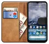 A book-style phone case with a phone inserted, showing cards and cash inside. Produktbild-Vorschau