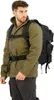 A man wearing a green jacket and black cargo pants, with a large black backpack on his back. Produktbild-Vorschau