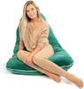 A woman is sitting on a large green beanbag chair. Náhled obrázku produktu