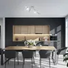 A modern kitchen and dining area with a track light fixture above a dining table and chairs. Anteprima dell’immagine prodotto
