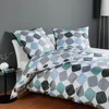 A neatly made bed with a geometric patterned duvet cover and pillows. Produktbild-Vorschau