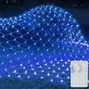 A net of blue LED lights draped over a bush and on the ground. Náhled obrázku produktu