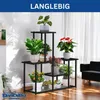 A multi-tiered black metal plant stand filled with various potted plants, placed in a well-lit room with sheer curtains in the background. Podgląd zdjęcia produktu