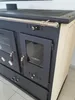 A close-up, angled view of a beige and dark gray wood-burning stove with a baking compartment and stovetop. Voir les images du produit