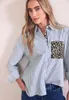 A woman wearing a striped shirt with a leopard print pocket. Produktbild-Vorschau