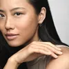 Close-up portrait of a woman wearing a silver heart-shaped earring. Voir les images du produit