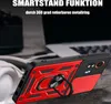 A red and black phone case with a ring holder is displayed on a textured surface, with a blurred laptop in the background. Produktbild-Vorschau