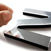 A hand is peeling protective film off a reflective, black-backed number '3' which is part of a larger decorative clock. Anteprima dell’immagine prodotto