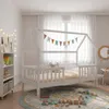A child's bedroom with a white house-shaped bed, a bookshelf, and toys on the floor. Náhled obrázku produktu