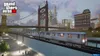 A train is traveling on a bridge over a body of water, with a city skyline in the background. The Grand Theft Auto logo is visible in the top left corner. Produktbild-Vorschau