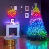 A Christmas tree decorated with multicolor lights and a star on top, placed in a room with a fireplace and a wreath on the wall. Produktbild-Vorschau