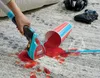 A hand is using a Shark StainStriker cleaner to clean up a red spill on a carpet. A spilled cup and a game controller are also visible. Podgląd zdjęcia produktu