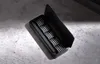 A black electric screwdriver set with multiple bits is shown in its open case, resting on a textured gray surface. Náhled obrázku produktu