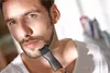 A man is trimming his beard with an electric trimmer. Podgląd zdjęcia produktu