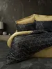 A bed with a black and gold geometric patterned duvet and gold pillowcases against a dark, textured wall. Produktbild-Vorschau