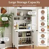 A white kitchen cabinet with various storage compartments and shelves, showcasing different items like bottles, glasses, and jars. Náhled obrázku produktu