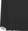 A black blackout roller blind is shown rolled up, with the white inner core visible. Produktbild-Vorschau