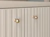 Close-up of two cabinet doors with ornate gold knobs. Náhľad obrázku produktu