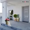 A modern house entrance with potted plants and a gray door. Produktbild-Vorschau