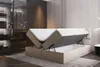 A bedroom scene with a bed that has its storage compartment open, revealing the mattress and storage space. Produktbild-Vorschau