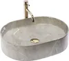 A grey oval basin with a gold drain and a gold faucet against a white background. Podgląd zdjęcia produktu
