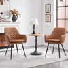 Two brown upholstered chairs are placed in a living room setting next to a small side table with a lamp and a drink. Produktbild-Vorschau