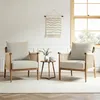 Two beige rattan chairs with comfortable cushions are placed in a well-lit room with a window and a small wooden table between them. Podgląd zdjęcia produktu