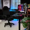 A gaming setup in a room with a gaming chair, desk, computer, and monitor. Produktbild-Vorschau